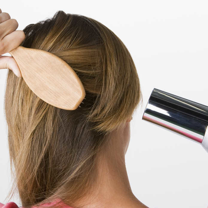 Woman brushing and drying hair